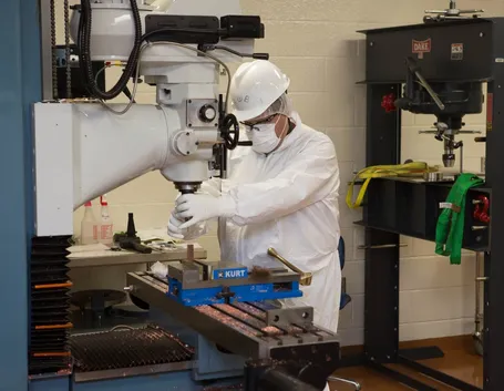 Operaio a lavoro con una macchina fresatrice industriale