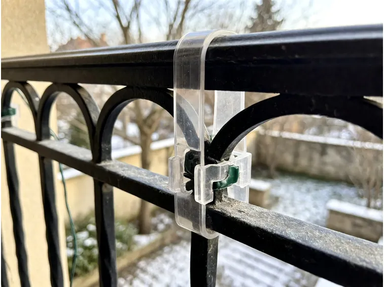 Fissare le catene luminose su balcone, facciata e alberi del giardino